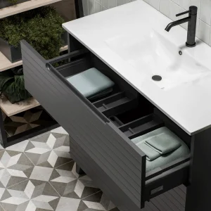 Mueble de baño Paris suspendido con 3 cajones y patas con lavabo porcelanico, con cajón abierto en negro