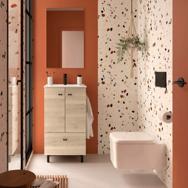 Conjunto de baño Inara con 2 puertas, 1 cajón y lavabo porcelánico, en madera clara, ambientado en baño con pared terracota