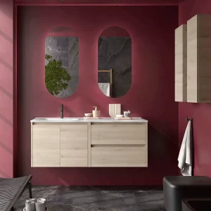Conjunto de baño Noja 120 cm con 2 cajones, 2 puertas, lavabo desplazado y espejo, en madera clara, ambientado en baño
