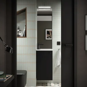Conjunto de baño Marville con una puerta y lavabo micro de carga mineral, en negro, ambientado en baño