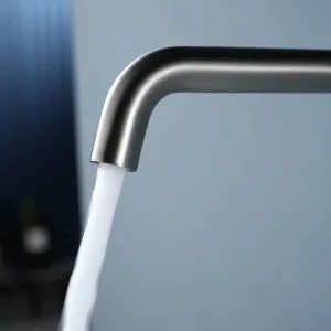 Grifo de lavabo empotrado monomando serie Bless de Imex, con agua saliendo del caño en gris oscuro