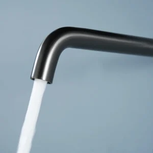 Grifo de lavabo empotrado monomando serie Bless de Imex, con agua saliendo del caño en negro