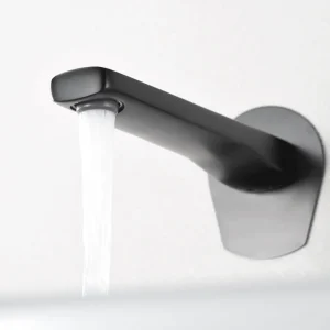 Grifo empotrado de lavabo monomando serie Delos de Imex, con agua saliendo del caño en gris oscuro