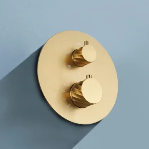 Conjunto de ducha termostático empotrado serie Bless de Imex, detalle del mando en dorado