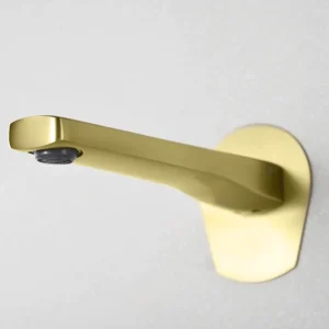 Grifo empotrado de lavabo monomando serie Delos de Imex, con agua saliendo del caño en dorado