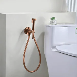 Grifería de bidé empotrada monomando serie Bless de Imex, instalada junto al inodoro en oro rosa