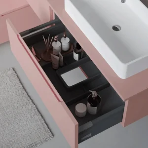 Mueble de baño Kairo suspendido con lavabo porcelánico y 2 cajones, con cajón abierto en rosa
