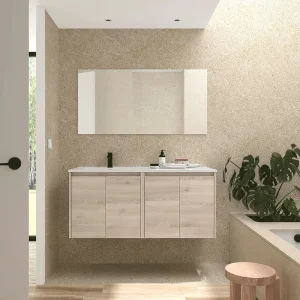Conjunto de baño Noja 120 cm con 4 puertas, lavabo desplazado y espejo incluido, en madera clara, ambientado en baño