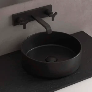 Lavabo sobre encimera Kandy circular en porcelana para baño moderno, en negro, ambientado en baño
